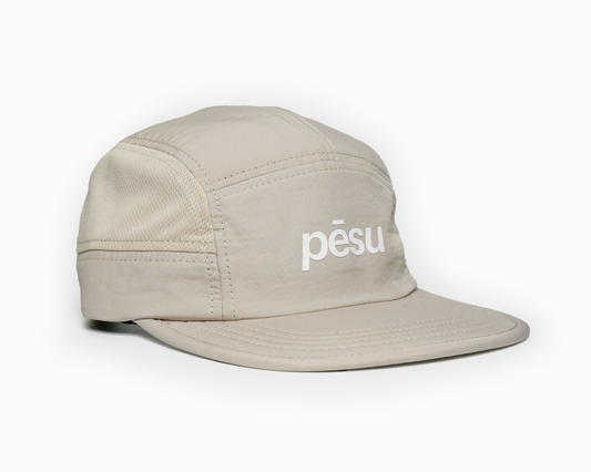 Pēsu beige lightweight performance 8 panel cap with breathable mesh panels, quick-dry fabric, moisture-absorbing sweatband and minimalist design for sport and lifestyle. White pēsu box logo on frontpanel.